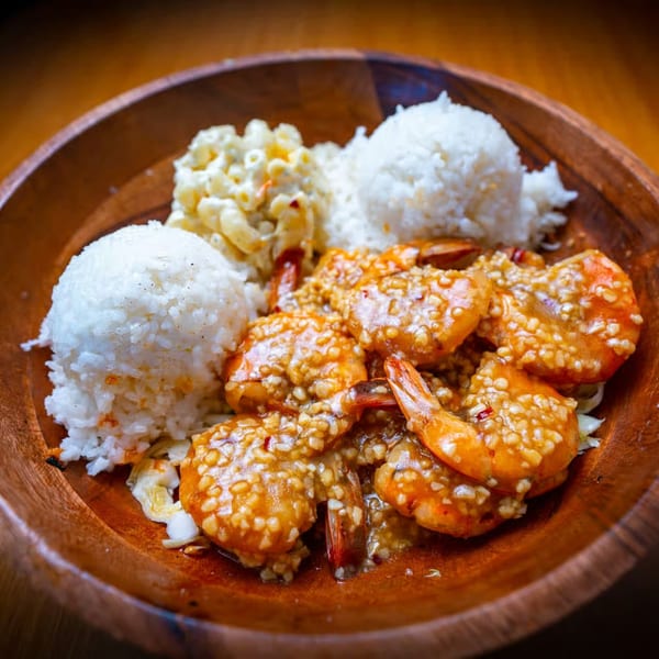 Hawaiian garlic shrimp plate with white rice and macaroni salad in a wooden bowl.