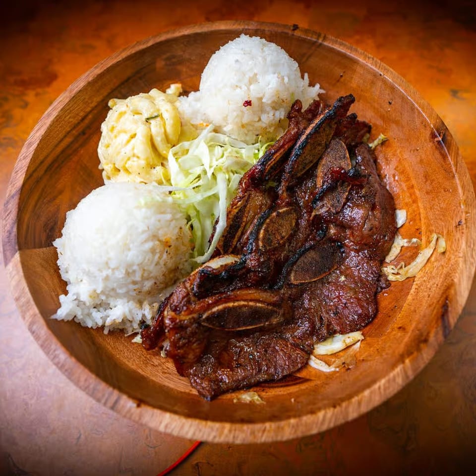 Hawaiian BBQ short ribs with two scoops of white rice, macaroni salad, and shredded cabbage.