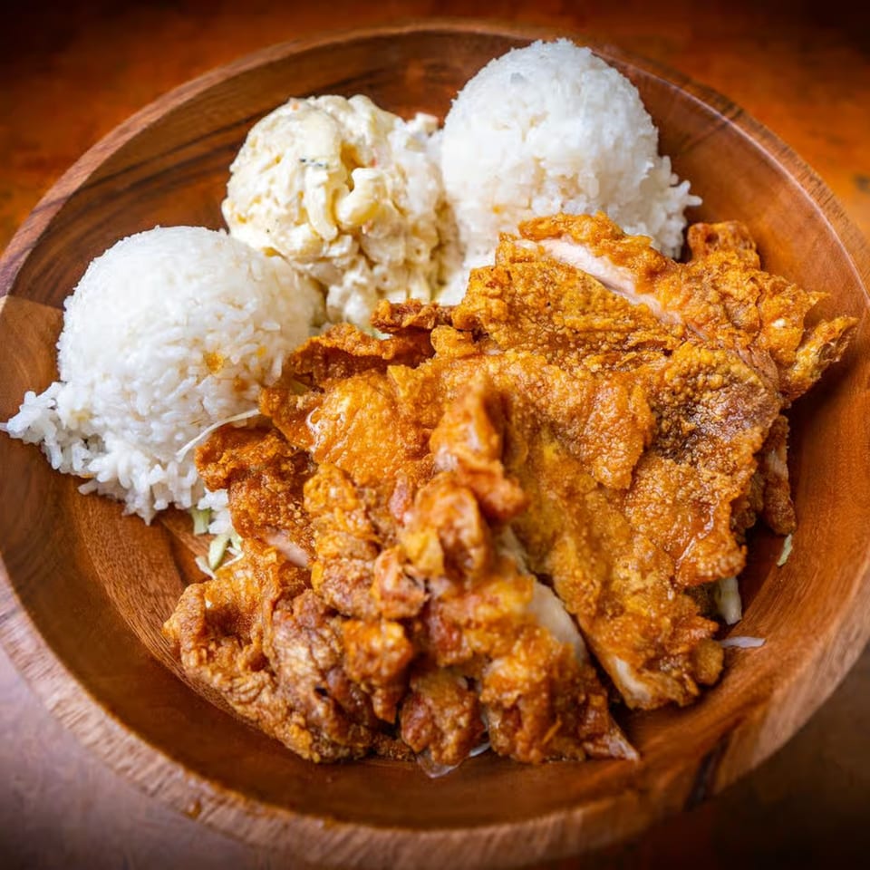 Crispy fried chicken, two scoops of white rice, and macaroni salad in a wooden bowl.